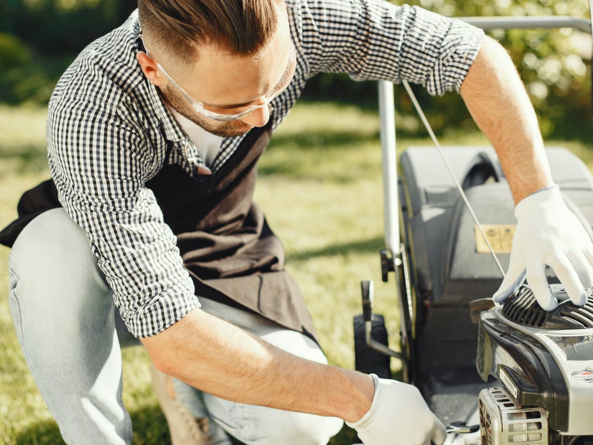Servis a oprava kosačky — ruky mechanika pri motore